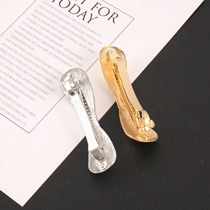 Macro detail of brushed metal hair clips showing gold and silver finishes with spring clasp