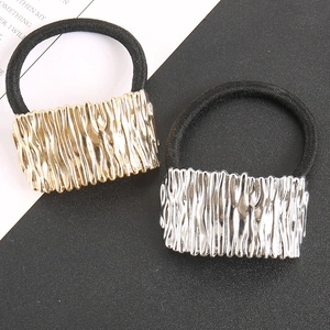 Macro detail of high-elastic black hair ties with textured gold and silver alloy buckles