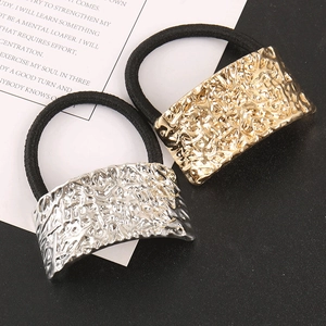 Dettaglio di elastici per capelli oro e argento con placca rettangolare martellata