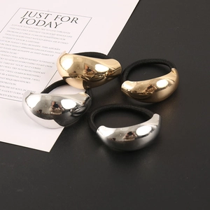 Detail von hochglanzpolierten metallischen Haargummis in Gold und Silber mit elastischem Band