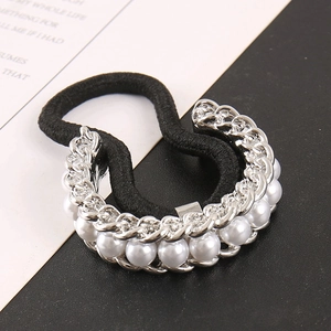 Close-up of black elastic hair tie with silver metal chain and white faux pearls inlay