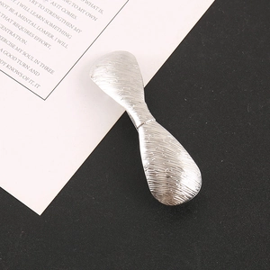 Close-up of a silver rectangular metal hair clip with a minimalist brushed texture finish