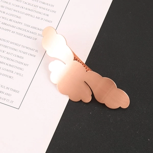 Macro detail of rose gold cloud hair clip showing textured metal finish and spring clamp