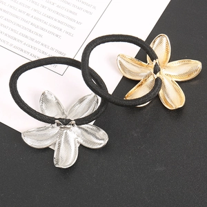 Macro detail of gold and silver flower hair ties with high-elasticity black rubber bands