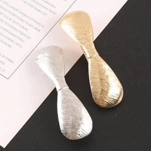 Detailed view of gold and silver geometric alloy hair clips with brushed metal texture