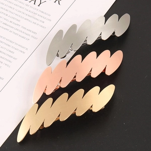 Dettaglio di fermagli per capelli in metallo ondulato in oro, oro rosa e argento