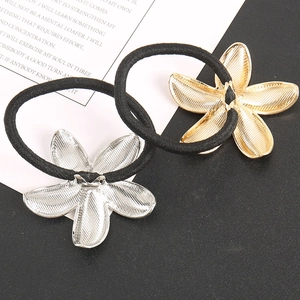 Detail view of gold and silver metallic flower hair ties with textured alloy finish