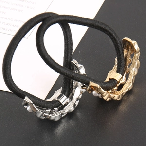 Detail of minimalist black elastic hair ties with gold and silver crescent moon pearl accents