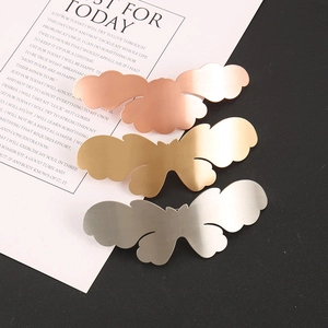 Detailed close-up of three butterfly metal hair clips in gold, silver, and rose gold finishes