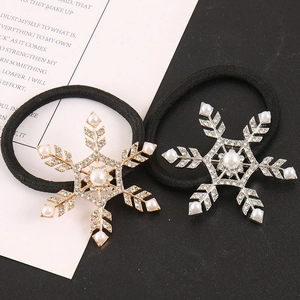 Detail of gold and silver snowflake hair ties with rhinestones and pearls on black elastic