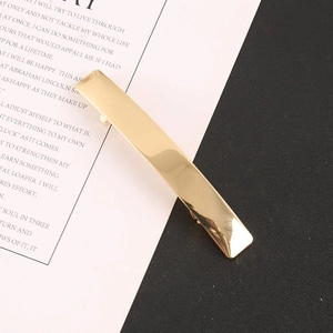 Detailed view of glossy rectangular gold hair clip with mirror polished alloy finish