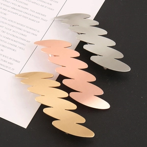 Dettaglio di fermagli per capelli ondulati in lega con finiture oro, argento e rosa