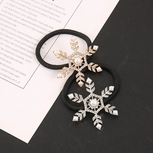 Detail of snowflake hair ties with pearls and rhinestones on black elastic bands