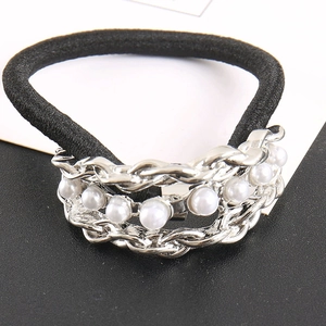 Close-up of black elastic hair band with silver metal chains and white faux pearls