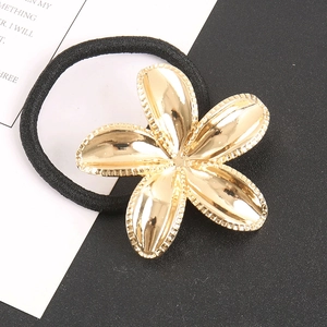 Elegant gold metal flower hair tie with high-elastic black rope on a stylish background