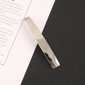 Detailed view of polished silver metal rectangular hair clip on monochrome background