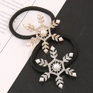 Detailed close-up of snowflake hair ties with rhinestones and pearls in gold and silver