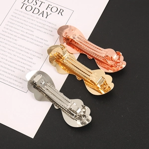 Macro detail of three metallic hair clips in gold, silver, and rose gold finishes