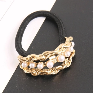 Detail of black elastic hair tie featuring gold braided chain and white faux pearls decor