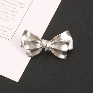Close-up of silver metal bow hair claw featuring elegant vertical stripe textures