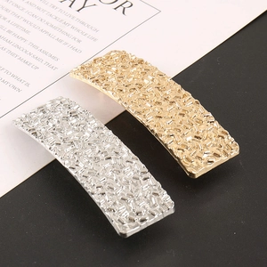 Vue détaillée de barrettes rectangulaires dorées et argentées avec texture martelée moderne