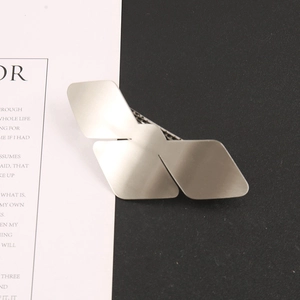 Macro detail of silver geometric bird-shaped hair clip with a brushed metal finish