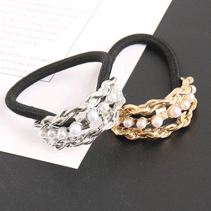Detailed macro view of black elastic hair ties with gold and silver pearl chain accents