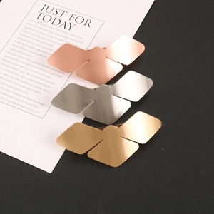 Detail view of geometric bird-shaped hair clips in gold, silver, and rose gold finishes