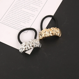 Détail d'élastiques à cheveux avec pendentifs géométriques en or et argent martelés