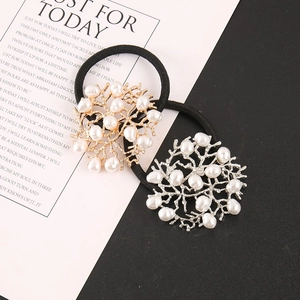 Detail view of gold and silver alloy coral hair ties with white imitation pearls