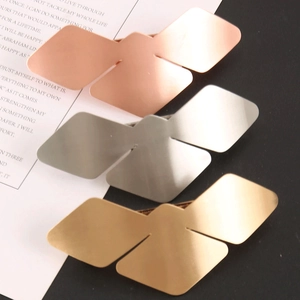 Macro shot of three geometric butterfly hair clips in gold, silver and rose gold colors