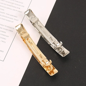 Minimalist rectangular gold and silver metal hair clips in a high-fashion creative setup
