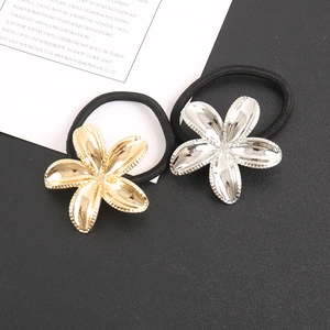 Detail of gold and silver flower hair ties with metallic petals and black elastic bands