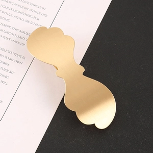 Detailed close-up of a minimalist matte gold metal hair clip with brushed texture finish