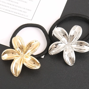 Detailed macro view of gold and silver metallic flower hair ties with textured petals