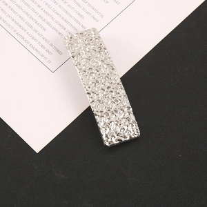 Vue détaillée de la barrette argentée avec texture micro-diamant étincelante sur fond minimal