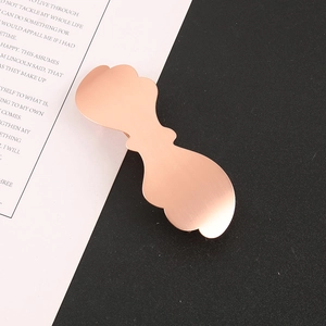 Close-up of rose gold wave-shaped hair clip with elegant brushed metal texture and detail