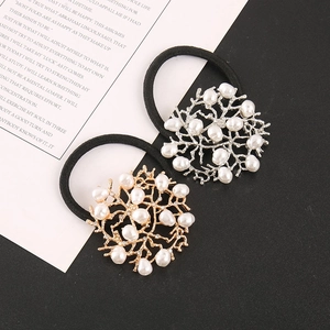 Detail of coral-shaped metal hair ties with white pearls and sparkling rhinestones