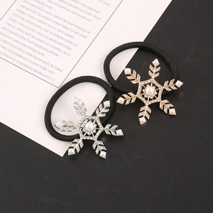Detail of snowflake hair ties with rhinestones and white pearls in gold and silver