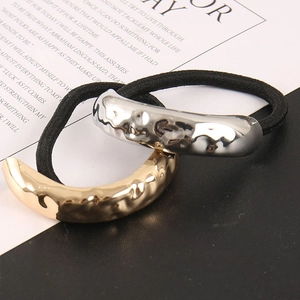Detail of minimalist gold and silver hair ties with hammered metal tube texture