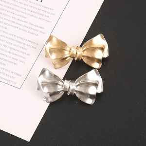 Elegant metal bow hair clips in gold and silver finish with brushed matte texture