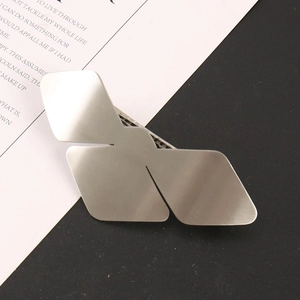 Macro detail of a silver geometric butterfly hair clip with a brushed matte metal finish