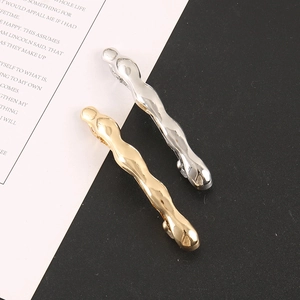 Detailansicht welliger Metall-Haarklammern in Gold und Silber mit glänzendem Finish