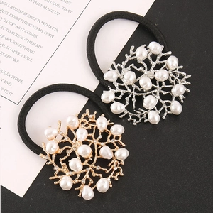 Detail of coral-shaped alloy hair ties with white faux pearls and black elastic bands