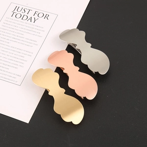 Detailed macro view of a 3-piece set of metal hair clips in gold, silver, and rose gold finishes