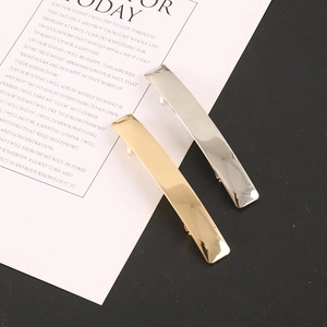 Close-up of elegant gold and silver metal hair clips with a polished rectangular design