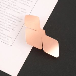 Macro detail of geometric rose gold hair clip with a brushed metal texture finish