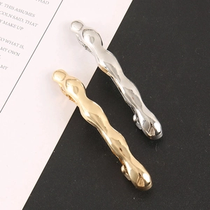 Detailansicht wellenförmiger Flüssigmetall-Haarspangen in Gold- und Silberoptik