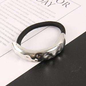 Detail of silver hammer-textured metal ornament on a high-elastic black hair tie