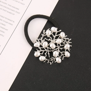 Detailed shot of silver coral alloy hair tie with white pearls and sparkling rhinestones